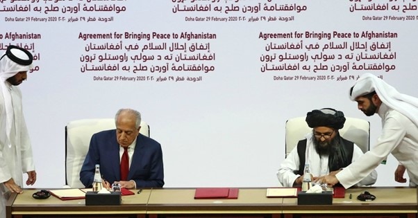 El enviado estadounidense Zalmay Khalilzad firma el acuerdo Doha con los talibanes afganos en febrero, 2020