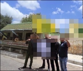 A group of people standing in front of a rainbow colored buildingDescription automatically generated with low confidence