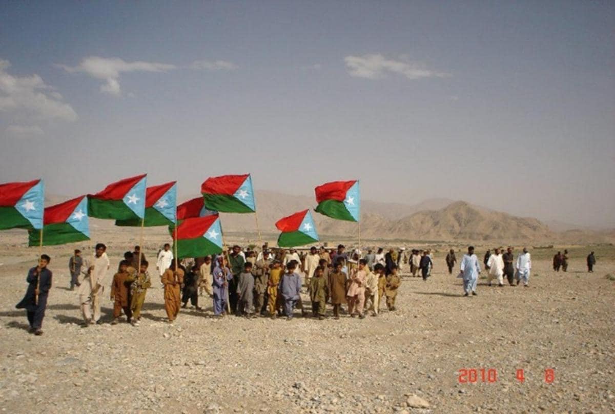 Pueblo Balochi enarbolando la bandera de Beluchistán.
