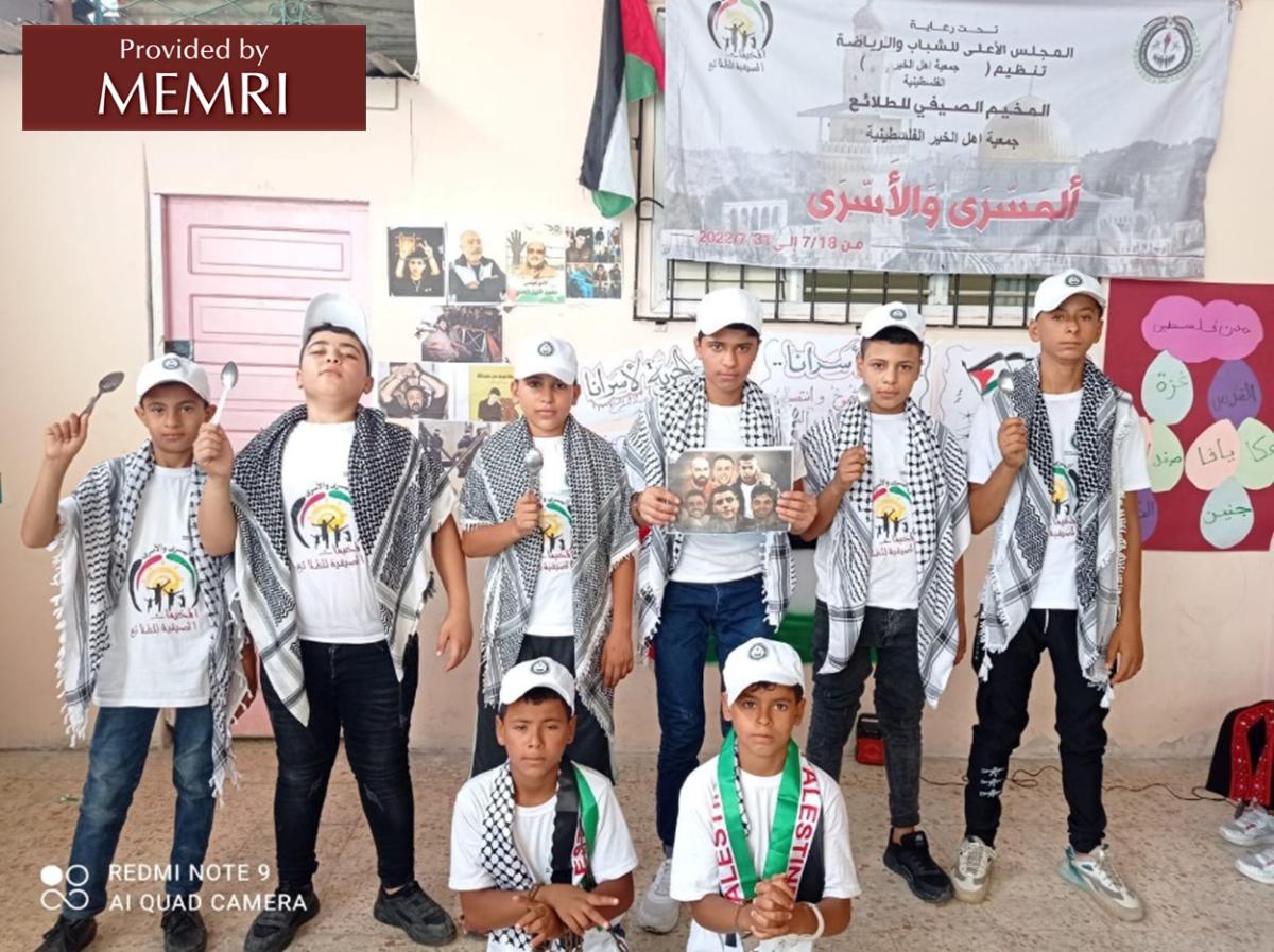 Ceremonia de clausura en los campamentos de Rafah y Gaza: Un chico sostiene una fotografía de los seis prisioneros y otros sostienen cucharas, aludiendo a las herramientas improvisadas que utilizaron los seis para cavar su túnel de escape (Facebook.com/hcyspalestine, 4 de agosto, 2022)