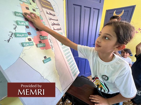 Chica en campamento de verano en Gaza junto a un mapa de "las ciudades de nuestra amada Palestina", que incluyen Acre, Tiberíades, Beit Shean, Jaffa, Ramla y Beersheva (Facebook.com/hcyspalestine, 3 de agosto, 2022)
