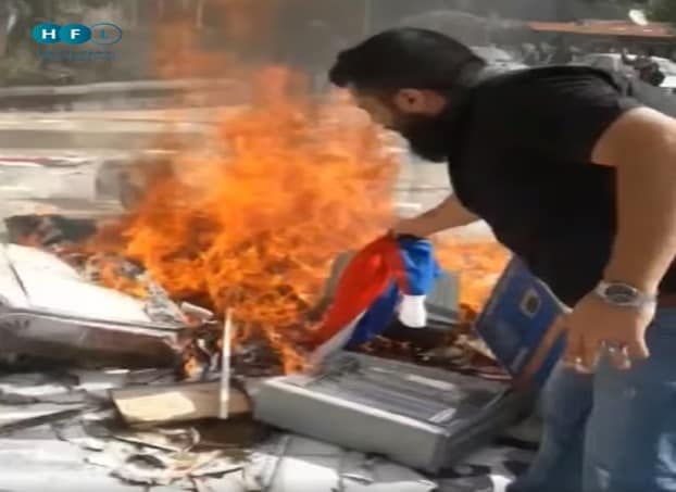 Manifestante quema una bandera rusa (imagen: Facebook.com/HoranFreeMedia, 4 de diciembre, 2022)