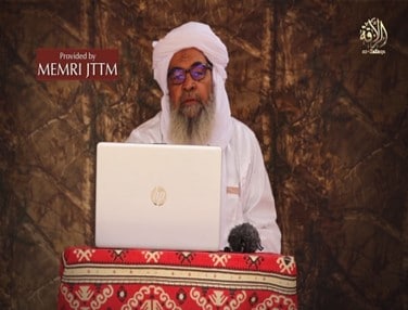 A person in white turban sitting at a computerDescription automatically generated